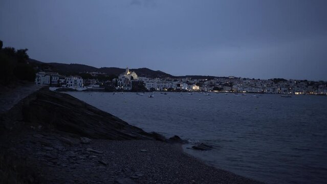 Nighttime Enchantment. Panoramic View of Cadaques with Soft Lights and Sea at Dusk. High quality 4k footage