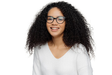 Portrait of smiling African American woman wears transparent eyewear and white jumper, being in...