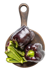Purple bell peppers on wooden cutting board isolated on white background. Top view.