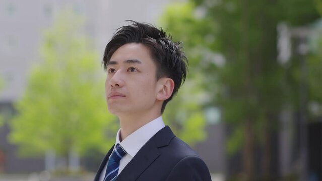 スーツを着た若い日本人ビジネスマンの夏のイメージ