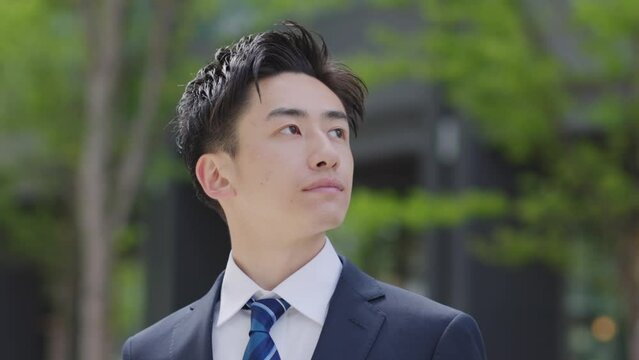 スーツを着た若い日本人ビジネスマンの夏のイメージ