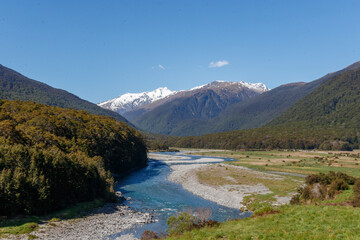 Fototapeta na wymiar River Bed the Haast Pass, New Zealand, with snow-capped mountains