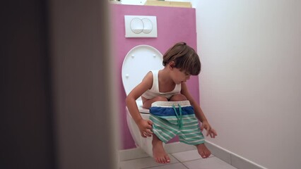 Child seated on toilet doing his needs