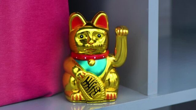 Maneki neko, japanese waving cat adorning the storefront of a trendy clothes boutique. This lucky feline figurine is popular symbol of good fortune and prosperity in Asian culture.