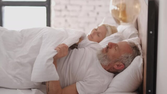 The middle age couple sleeping in the bed. slow motion