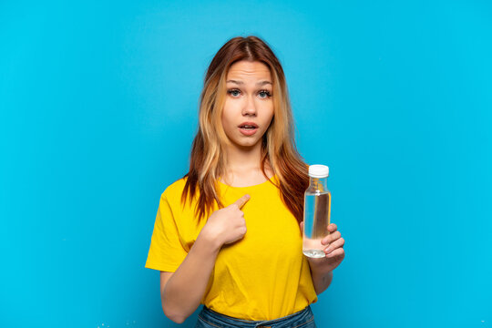 Teenager girl with a bottle of water over isolated blue background with surprise facial expression