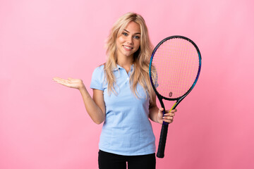 Young Russian woman playing tennis isolated on purple background holding copyspace imaginary on the...