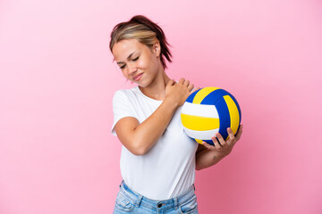 Young Russian woman playing volleyball isolated on pink background suffering from pain in shoulder...