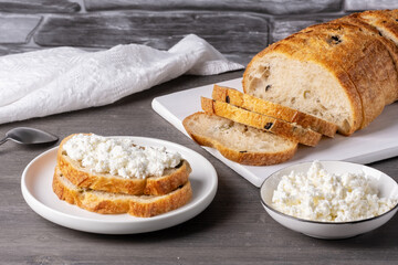 Sandwiches with cottage cheese and bread with olives on a gray table