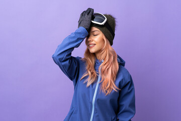 Skier teenager girl with snowboarding glasses over isolated purple background has realized...