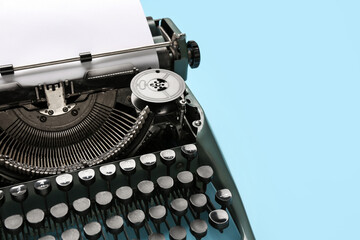 Vintage typewriter with blank paper sheet on blue background - Powered by Adobe