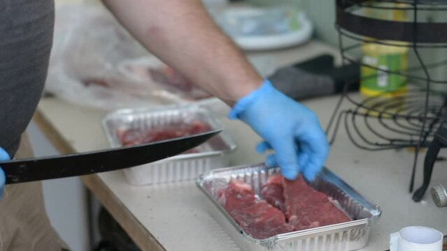 close up view on men's hands preparing meat for BBQ. 