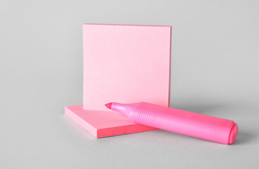 Pink sticky notes with marker on grey background
