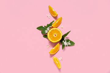 Oranges with blooming branch on pink background