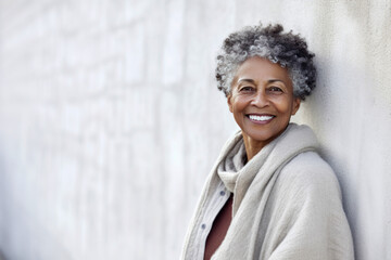 60 year old woman with grey hair posing in front of a wall. Generative AI.