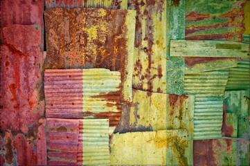 Abstract background of the flag of Guinea painted on rusty corrugated iron sheets