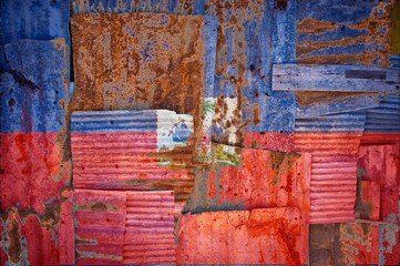 Abstract background of the flag of Haiti painted on rusty corrugated iron sheets