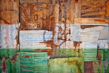 Flag of India on rusty corrugated iron sheets forming a wall or a fence