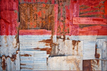 Flag of Indonesia on rusty corrugated iron sheets forming a wall or a fence