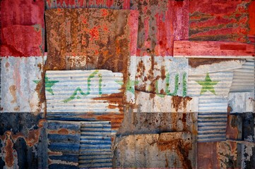Flag of Iraq on rusty corrugated iron sheets forming a wall or a fence