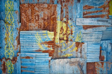 Flag of Kazakhstan on rusty corrugated iron sheets forming a wall or a fence