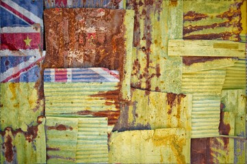 Shot of the flag of Niue painted on rusty corrugated iron sheets overlapping to form a wall