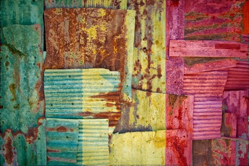 Flag of Senegal painted onto rusty corrugated iron sheets overlapping to form a wall or fence