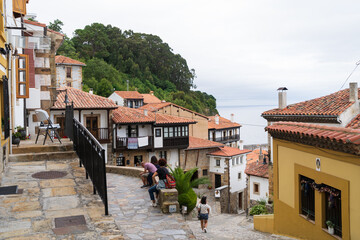 Vista de una calle de la villa marinera de Lastres, Asturias, con el mar al fondo.