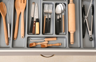 Open kitchen drawer with different silver cutlery