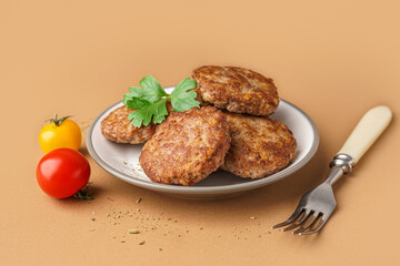 Cutlets with tomatoes, parsley and fork on beige background
