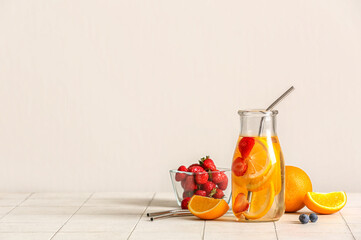 Fototapeta Bottle of infused water with orange slices on white tile table obraz
