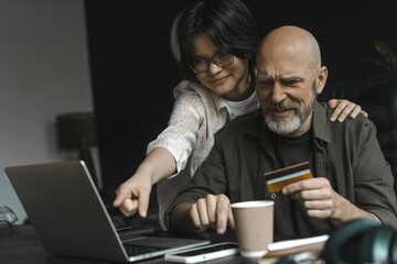 Dad and daughter enjoy online shopping together. Options, purchases, and embracing convenience of...