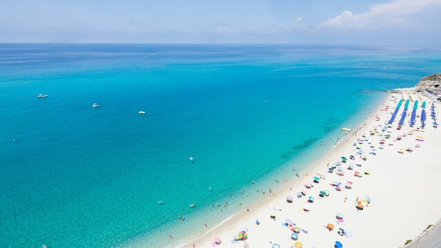 Aerial View Of A Sandy Beach With Colorful Table Umbrellas Under Blue Sky In Sicily Coast, Italy