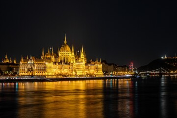 Fototapeta na wymiar View of the illuminated Hungarian Parliament Building at the night reflected in waters in Budapest