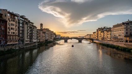 Obraz premium Beautiful view of a bridge over a river during a sunset in Florence, Tuscany, Italy