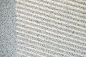 Shade from the blinds on the wall. Beautiful window blind shadow from morning sunlight on grey empty wall