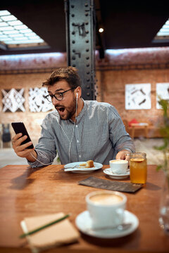  man looking at his phone and making a suprise face excpression.