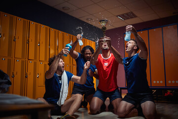 Group of four men team players in locker room celebrating success together, holding golden medal...