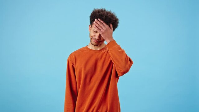 Disappointed man presses palm to forehead feeling ashamed