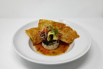 Non-traditional but delicious sushi served with nachos on the plate on the empty white background