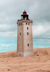 Vertical shot of the Rubjerg Knude lighthouse on sand dunes in Lokken, Denmark