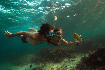 Couple is making photo underwater - Powered by Adobe