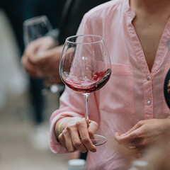 Red wine poured into a glass by a waiter at a tasting in a restaurant.