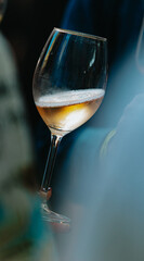 White wine poured into a glass by a waiter at a tasting in a restaurant.