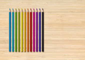 Colored pencil group isolated on wooden background. Horizontal background