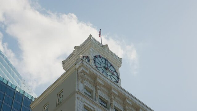Low angle shot of a clock tower with a flag in Downtown Vancouver, BC, Canada