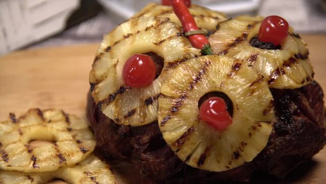 Holiday meal featuring cooked pineapple ham, tomato, chili pepper and garnish
