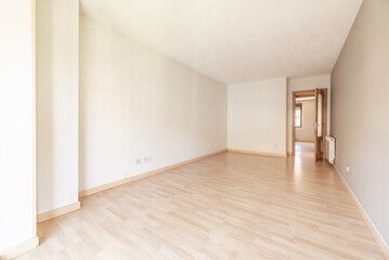A spacious empty living room with a wooden floor