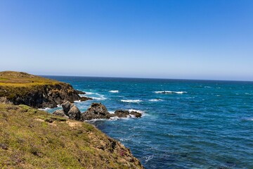 Rocky cliff on the blue ocean during a sunny day