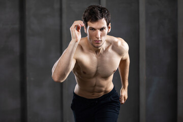 Fototapeta na wymiar Strong handsome man torso exercises in gym